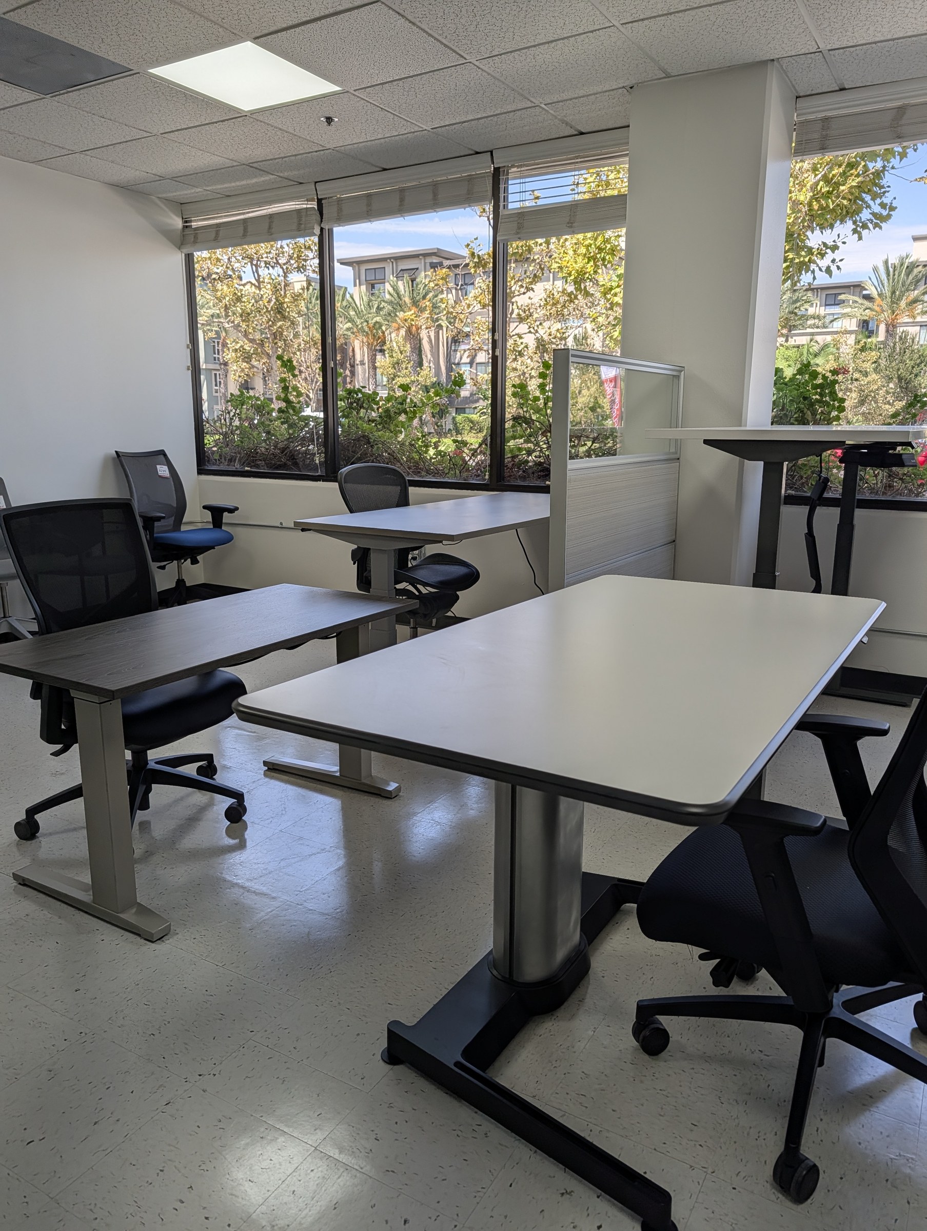 Height adjustable desks and task chairs set up by the windows in the Irvine showroom