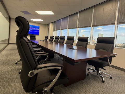 HON Preside 14 foot mahogany conference table with grommets and Friant New Madison high back leather chairs in a conference room in Houston, Texas